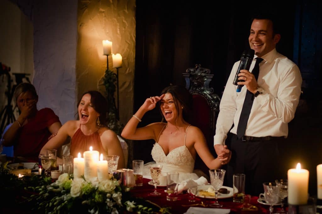 Couple laughing by candle light during wedding speech at Kinnitty Castle