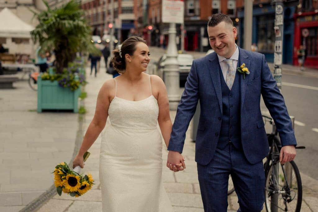 Smiling newlyweds walking in Dublin City