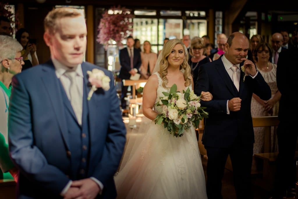 Emotional wedding moment at top of wedding aisle
