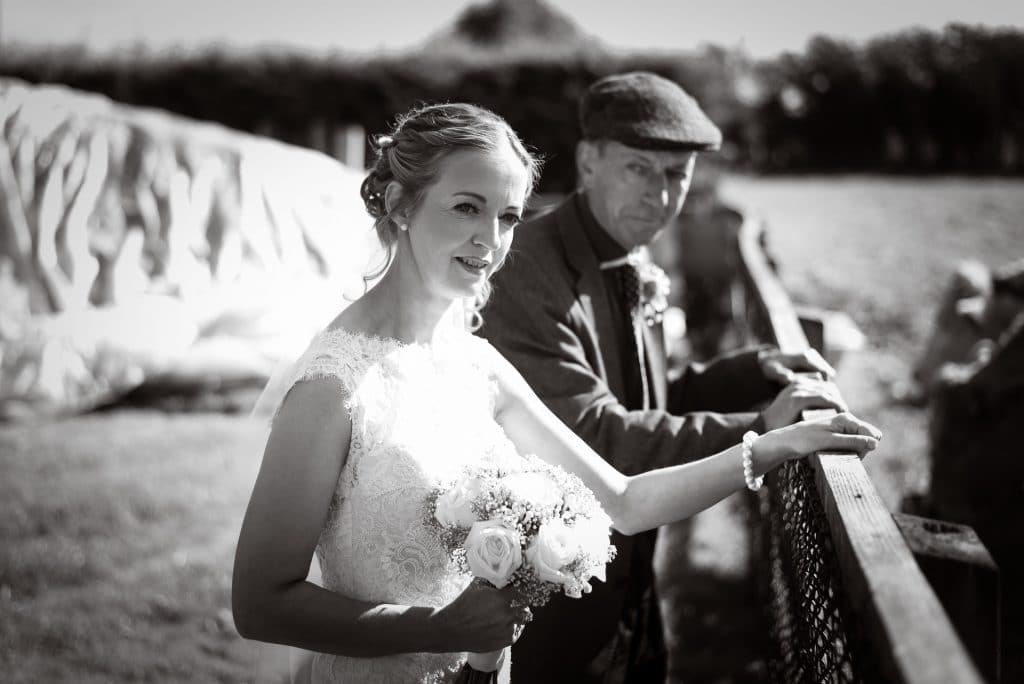 Bride and uncle visiting cattle on wedding morning